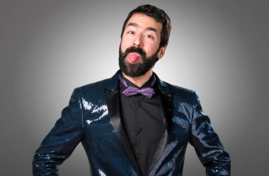 Dilini gri arka plan üzerinde yaptırmayı payet ceket ile yakışıklı adam