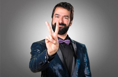 İki gri arka plan üzerinde sayma payet ceket ile yakışıklı adam