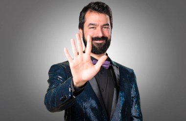 Payet ceket gri arka plan üzerinde beş sayma ile yakışıklı adam