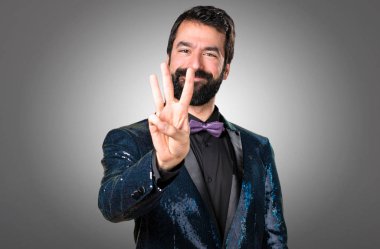 Payet ceket gri arka plan üzerinde üç sayım ile yakışıklı adam