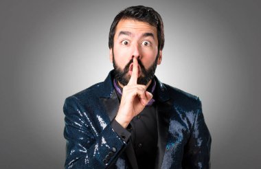 Payet ceket gri arka plan üzerinde yapım sessizlik hareketi ile yakışıklı adam