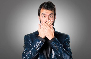 Yakışıklı adam ağzını gri arka plan üzerinde kapsayan payet ceket ile