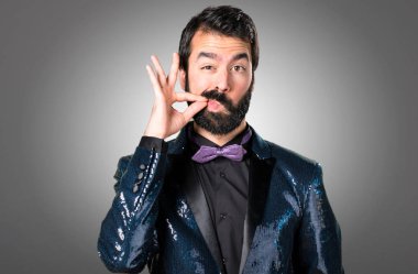 Payet ceket gri arka plan üzerinde yapım sessizlik hareketi ile yakışıklı adam