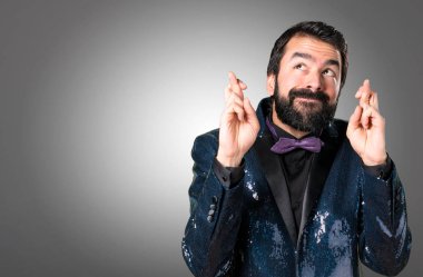 Payet ceket gri arka plan üzerinde geçiş parmaklarıyla yakışıklı adam