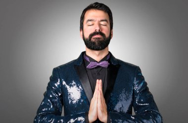 Payet ceket gri arka plan üzerinde zen pozisyonda olan yakışıklı adam