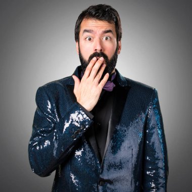 Payet ceket gri arka plan üzerinde yapım sürpriz hareketi ile yakışıklı adam