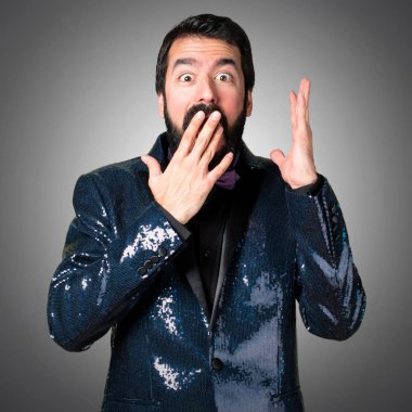 Payet ceket gri arka plan üzerinde yapım sürpriz hareketi ile yakışıklı adam