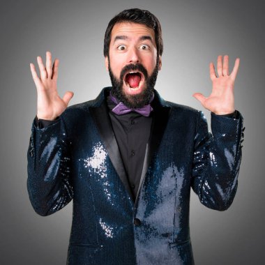 Payet ceket gri arka plan üzerinde yapım sürpriz hareketi ile yakışıklı adam