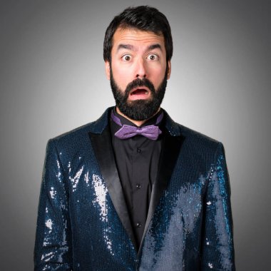 Payet ceket gri arka plan üzerinde yapım sürpriz hareketi ile yakışıklı adam