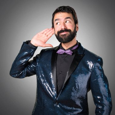 Payet ceket gri arka plan üzerine bir şey dinleme ile yakışıklı adam