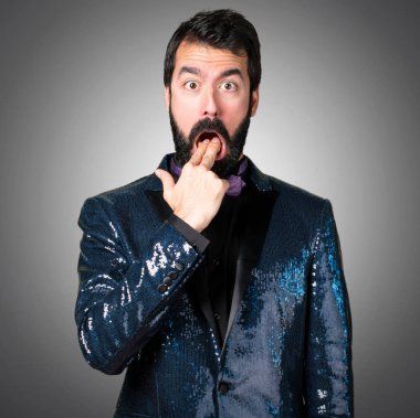 Payet ceket gri arka plan üzerine kusma jest yapma ile yakışıklı adam