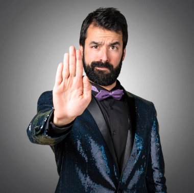 Yakışıklı adamla payet ceket gri arka plan üzerinde kırmızı yapma