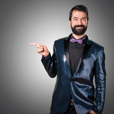 Payet ceket gri arka plan üzerinde lateral işaret ile yakışıklı adam