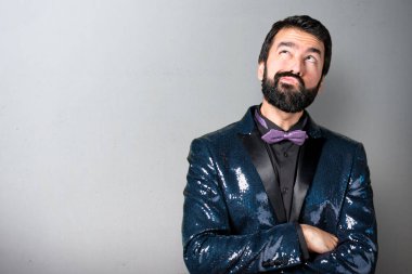 Payet ceket gri arka plan üzerine şüpheleri olan yakışıklı adam