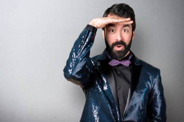 Bir şey gri arka plan üzerinde gösterilen payet ceket ile yakışıklı adam