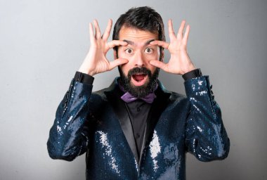 Bir şey gri arka plan üzerinde gösterilen payet ceket ile yakışıklı adam