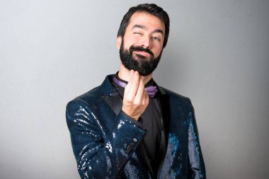 Payet ceket gri arka plan üzerinde yapma para hareketi ile yakışıklı adam