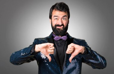 Payet ceket gri arka plan üzerinde kötü sinyal verme ile yakışıklı adam