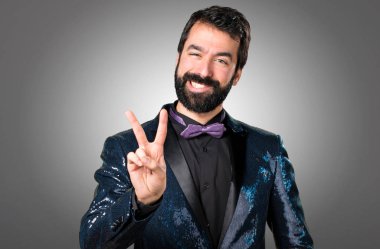 Payet ceket gri arka plan üzerinde yapım zafer hareketi ile yakışıklı adam