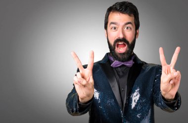 Payet ceket gri arka plan üzerinde yapım zafer hareketi ile yakışıklı adam