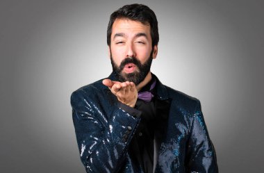 Payet ceket gri arka plan üzerinde bir öpücük gönderme ile yakışıklı adam