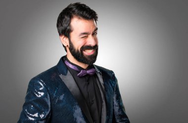 Payet ceket gri arka plan üzerinde göz kırpıyor ile yakışıklı adam