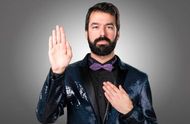 Payet ceket gri arka plan üzerine yemin yapma ile yakışıklı adam