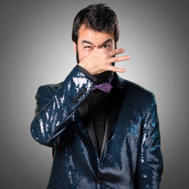 Payet ceket gri arka plan üzerinde kötü jest kokulu yapma ile yakışıklı adam