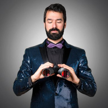 Payet ceket gri arka plan üzerinde dürbün ile yakışıklı adam