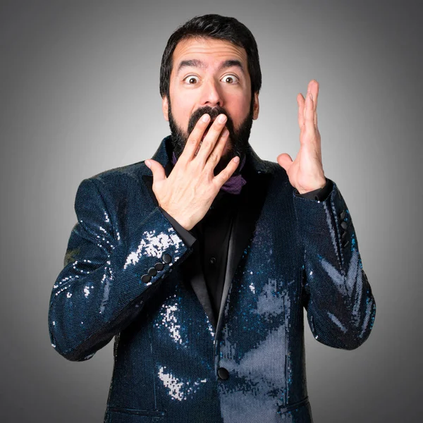 Payet ceket gri arka plan üzerinde yapım sürpriz hareketi ile yakışıklı adam