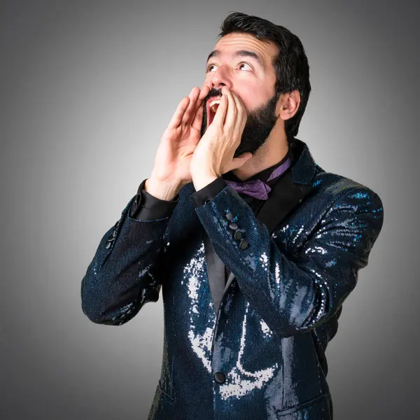 Payet ceket gri arka plan üzerine bağırarak ile yakışıklı adam