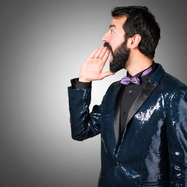 Payet ceket gri arka plan üzerine bağırarak ile yakışıklı adam