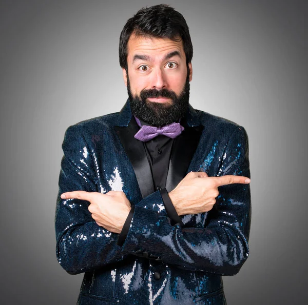 Payet ceket gri arka plan üzerine şüpheleri Laterallerin işaret eden yakışıklı adam