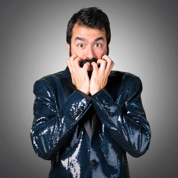 Payet ceket gri arka plan üzerinde korkmuş yakışıklı adam