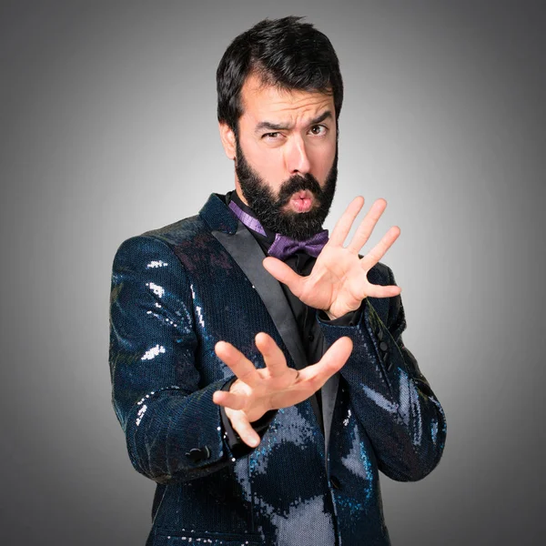 Payet ceket gri arka plan üzerinde korkmuş yakışıklı adam