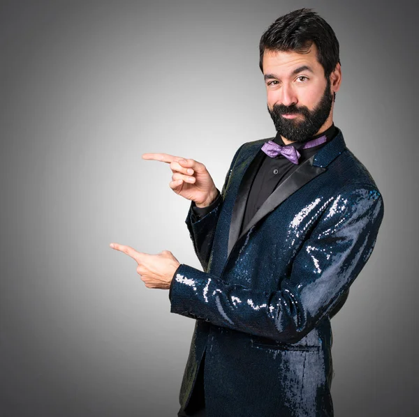 Hombre Guapo Con Chaqueta Lentejuelas Apuntando Hacia Lateral Sobre Fondo —  Fotos de Stock