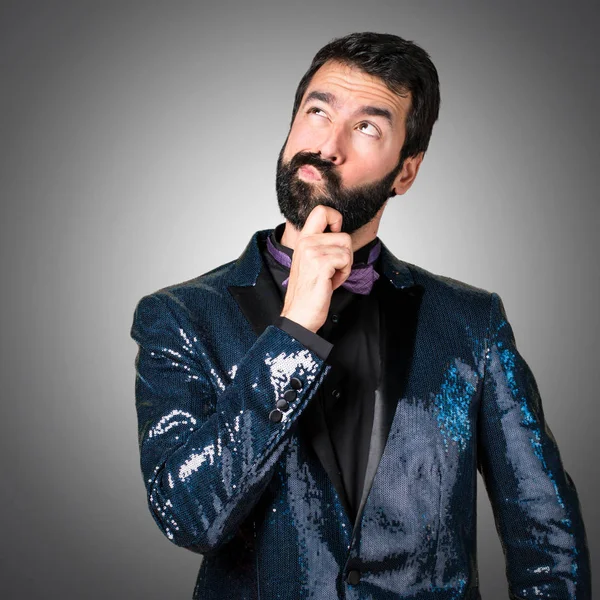 Payet ceket düşünce gri arka plan ile yakışıklı adam