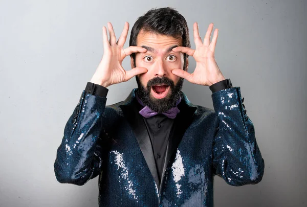 Bir şey gri arka plan üzerinde gösterilen payet ceket ile yakışıklı adam