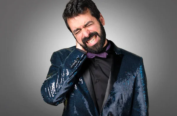 Payet ceket gri arka plan üzerinde boyun ağrısı ile yakışıklı adam