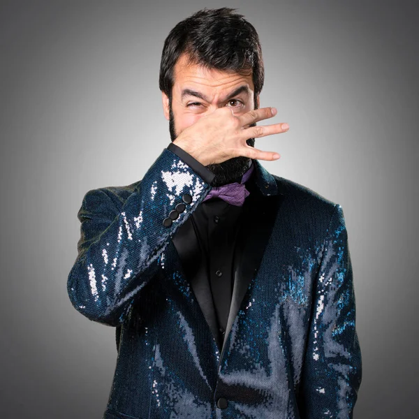 Payet ceket gri arka plan üzerinde kötü jest kokulu yapma ile yakışıklı adam