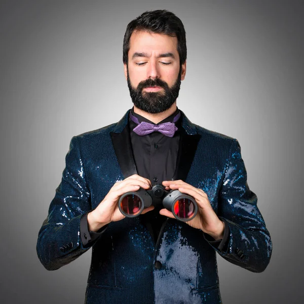 Payet ceket gri arka plan üzerinde dürbün ile yakışıklı adam