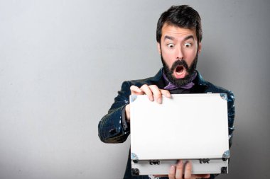 Bir evrak çantası gri arka plan üzerinde tutarak payet ceket ile yakışıklı adam