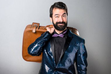 Yakışıklı bir vintage çanta gri arka plan üzerinde tutarak payet ceket ile