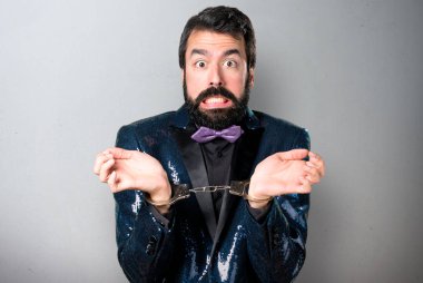 Payet ceketle yakışıklı adamla gri arka plan üzerinde kelepçe