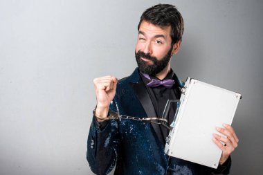 Yakışıklı bir çanta ile tutarak payet ceket ile gri arka plan üzerinde kelepçe