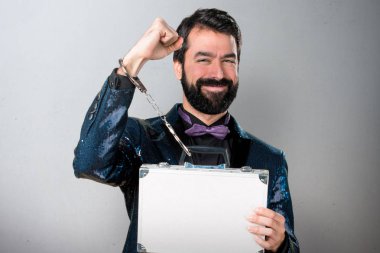 Yakışıklı bir çanta ile tutarak payet ceket ile gri arka plan üzerinde kelepçe