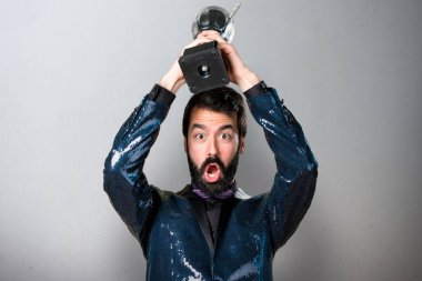 Bir kupa gri arka plan üzerinde tutarak payet ceket ile yakışıklı adam