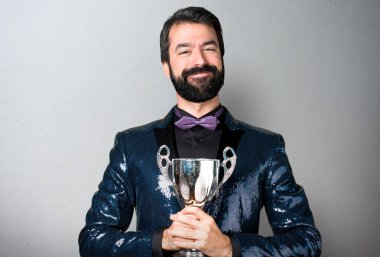 Bir kupa gri arka plan üzerinde tutarak payet ceket ile yakışıklı adam