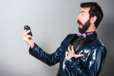Vintage saat gri arka plan üzerinde tutarak payet ceket ile yakışıklı adam