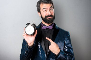 Vintage saat gri arka plan üzerinde tutarak payet ceket ile yakışıklı adam